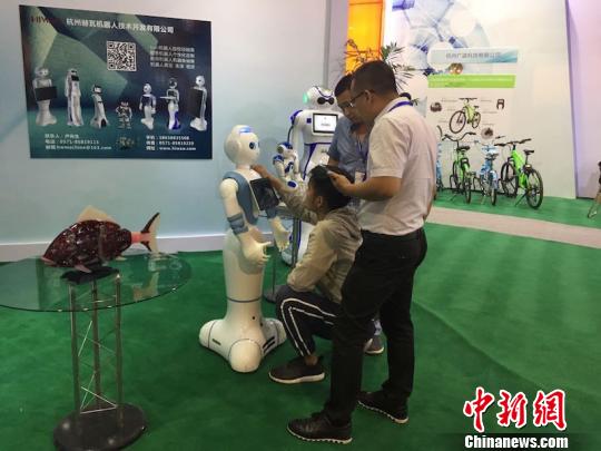 第九届旅博会开幕式上,观众在了解智能机器人 陈洁 摄